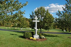 A ten-foot-high granite cross greets visitors at the entrance to the cemetery.